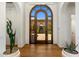 Elegant foyer with arched wood door and brick-paved courtyard view at 21397 N 78Th St, Scottsdale, AZ 85255
