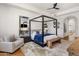Spacious main bedroom suite with a four-poster bed, accent chair, and modern decor at 21397 N 78Th St, Scottsdale, AZ 85255