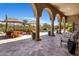 Covered patio with travertine floors, elegant columns, dining area, and seating overlooking the beautiful backyard at 21397 N 78Th St, Scottsdale, AZ 85255