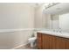 Well-lit bathroom with a wooden vanity, single sink, and white toilet, offering functionality at 2143 N Chestnut Cir, Mesa, AZ 85213