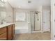 Bright bathroom featuring a tub, glass shower and vanity with wood cabinets at 2143 N Chestnut Cir, Mesa, AZ 85213