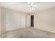 Well-lit bedroom featuring a ceiling fan, closet, and soft neutral carpeting at 2143 N Chestnut Cir, Mesa, AZ 85213