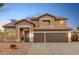 Inviting two-story home with a three-car garage, desert landscaping, and stone accents at 2143 N Chestnut Cir, Mesa, AZ 85213