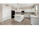 Modern kitchen with white cabinets, a black fridge, and central island at 2143 N Chestnut Cir, Mesa, AZ 85213