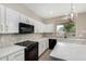 Updated kitchen with white cabinets, black appliances, and stone backsplash at 2143 N Chestnut Cir, Mesa, AZ 85213