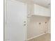 Laundry room features storage cabinets, tile flooring, and access door at 2143 N Chestnut Cir, Mesa, AZ 85213