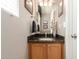 Charming powder room featuring a granite countertop, wood cabinetry, and decorative accents at 2167 S Luther Ave, Mesa, AZ 85209
