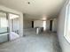 View of the open living room, featuring large sliding glass door, grey concrete flooring and grey unfinished walls at 2356 E Spur Dr, San Tan Valley, AZ 85140