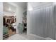 Bathroom featuring a closet, shower with white shower curtain, and shelving for storage and organization at 25457 W Clanton Ave, Buckeye, AZ 85326