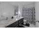 Well lit bathroom with a double sink vanity, a full mirror, and a shower with a patterned shower curtain at 25457 W Clanton Ave, Buckeye, AZ 85326