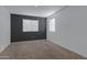 Bedroom with neutral carpet, two windows, and a dark gray accent wall at 25457 W Clanton Ave, Buckeye, AZ 85326