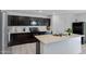 Well-lit kitchen features a kitchen island, tile flooring, and sleek dark wood cabinetry at 25457 W Clanton Ave, Buckeye, AZ 85326