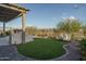 Backyard oasis with lush artificial grass, an outdoor kitchen and seating area at 26673 W Ponderosa Ln, Buckeye, AZ 85396