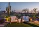Relaxing backyard seating area surrounded by desert flora, offering a tranquil outdoor retreat at 26673 W Ponderosa Ln, Buckeye, AZ 85396