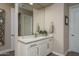 Bathroom vanity with granite countertop, double doors, brushed nickel faucet, and decorative mirror at 26673 W Ponderosa Ln, Buckeye, AZ 85396