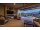 Elegant covered patio with a cozy fireplace and views of the sparkling pool and lush landscaping at 26673 W Ponderosa Ln, Buckeye, AZ 85396