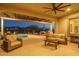 Spacious covered patio with comfortable seating, a ceiling fan, and overlooks a sparkling pool at 26673 W Ponderosa Ln, Buckeye, AZ 85396