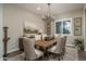 Cozy dining room with rustic table, patterned rug, and shuttered windows at 26673 W Ponderosa Ln, Buckeye, AZ 85396