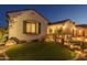 Charming home exterior featuring manicured lawn, stone accents, and inviting lighting at 26673 W Ponderosa Ln, Buckeye, AZ 85396