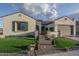 Charming single-story home featuring a manicured lawn, stone accents, and a two-car garage at 26673 W Ponderosa Ln, Buckeye, AZ 85396