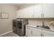 Well-appointed laundry room with modern appliances, ample cabinet space, and a sleek countertop at 26673 W Ponderosa Ln, Buckeye, AZ 85396