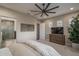 Inviting main bedroom featuring a ceiling fan, natural light, and an ensuite bathroom with tiled shower at 26673 W Ponderosa Ln, Buckeye, AZ 85396