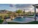 Backyard pool featuring a rock waterfall, desert landscaping, artificial grass and mountain views at 26673 W Ponderosa Ln, Buckeye, AZ 85396