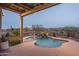 Beautiful pool with a rock waterfall feature and desert landscaping at 26673 W Ponderosa Ln, Buckeye, AZ 85396