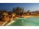 Beautiful pool with a rock waterfall feature, set against a desert landscape at 26673 W Ponderosa Ln, Buckeye, AZ 85396