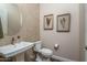 Stylish powder room featuring a pedestal sink, decorative accents, and modern fixtures at 26673 W Ponderosa Ln, Buckeye, AZ 85396
