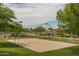 Outdoor sand volleyball court surrounded by lush landscaping and green spaces at 26673 W Ponderosa Ln, Buckeye, AZ 85396