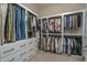 Spacious walk-in closet with custom shelving, drawers, and ample hanging space for clothes and accessories at 26673 W Ponderosa Ln, Buckeye, AZ 85396