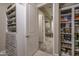 Bright walk-in closet with custom built-in shelves and drawers, providing organized storage for shoes and apparel at 26673 W Ponderosa Ln, Buckeye, AZ 85396