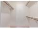 Walk-in closet features white walls, built-in shelving and wooden rods at 3031 N Civic Center Plz # 112, Scottsdale, AZ 85251