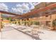 Community common area with lounge chairs and dining tables with shade and greenery at 3031 N Civic Center Plz # 112, Scottsdale, AZ 85251