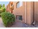 Condo exterior featuring low windows and lush green bushes with natural rock landscaping around the building at 3031 N Civic Center Plz # 112, Scottsdale, AZ 85251