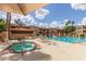 Community pool area featuring a spa, lounge chairs, and well-maintained landscaping at 3031 N Civic Center Plz # 112, Scottsdale, AZ 85251