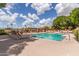 Community pool with lounge chairs and shaded seating areas on a bright sunny day with blue skies at 3031 N Civic Center Plz # 112, Scottsdale, AZ 85251