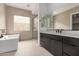 Bathroom featuring a soaking tub, glass shower, dark cabinets, and neutral tile at 33857 N Borgata Trl, San Tan Valley, AZ 85144