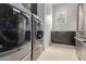 Laundry room with modern appliances, cabinets, countertop, and neutral tile flooring at 33857 N Borgata Trl, San Tan Valley, AZ 85144
