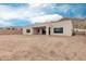Rear exterior view showcasing a stucco home with a spacious gravel yard and desert landscaping, set against a mountain backdrop at 33857 N Borgata Trl, San Tan Valley, AZ 85144