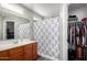 A cozy bathroom featuring a single sink vanity, shower with curtain, and a closet at 343 N 169Th Ave, Goodyear, AZ 85338