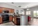 Cozy kitchen featuring wood cabinets, black appliances, and an open design leading to the living area at 343 N 169Th Ave, Goodyear, AZ 85338