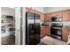 The kitchen features stainless steel refrigerator, wooden cabinetry, and modern appliances at 343 N 169Th Ave, Goodyear, AZ 85338