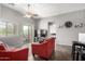Bright living room with plush red seating, ceiling fan, and sliding glass doors to balcony at 343 N 169Th Ave, Goodyear, AZ 85338