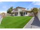 A home's backyard with lawn leading to the waterfront, complemented by mature trees at 3520 N 110Th Ave, Avondale, AZ 85392