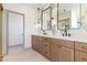 Bathroom featuring double vanities, marble backsplash, and wood cabinets at 3520 N 110Th Ave, Avondale, AZ 85392