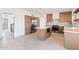 Open kitchen features island with microwave, stainless steel refrigerator, and view of staircase at 3520 N 110Th Ave, Avondale, AZ 85392