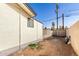 Side view of a property reveals gravel, partial brick wall, and healthy shrubs with a palm tree at 3733 W Flynn Ln, Phoenix, AZ 85019