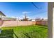 A spacious grassy backyard area enclosed by a tall brick wall, with lush plant life at 3733 W Flynn Ln, Phoenix, AZ 85019